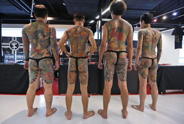 Participantes exibem tatuagens feitas pelo artista taiwanês Diau-An (Foto: Kin Cheung/AP)