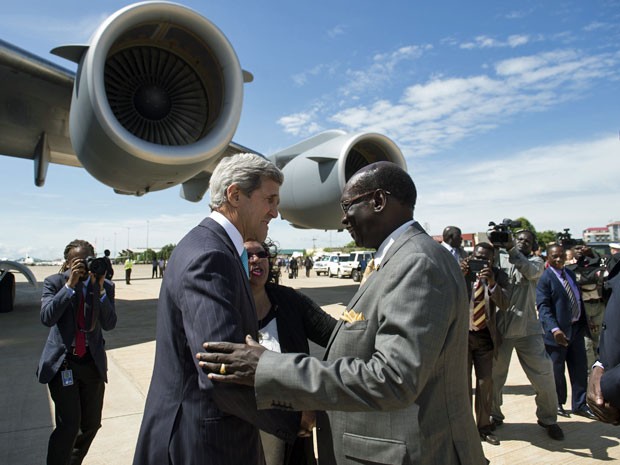 Ministro dos negócios estrangeiros do Sudão do Sul, Barnabé Mariano Benjamin, cumprimenta John Kerry após a sua chegada a bordo de um avião militar dos EUA no Aeroporto Internacional de Juba nesta sexta (2) (Foto: Saul Loeb/ AFP)